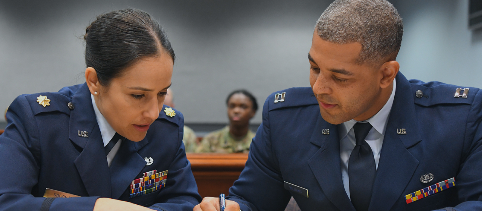 Air Force JAGs talking in a court room